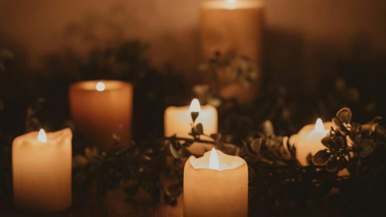 white pillar candle on brown wooden table