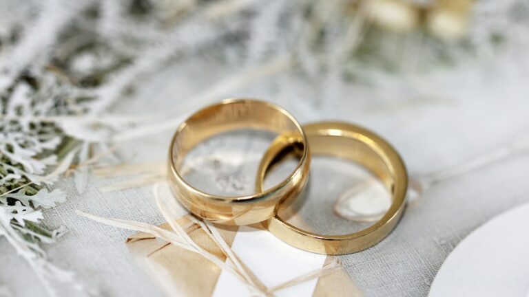 gold wedding band on white textile