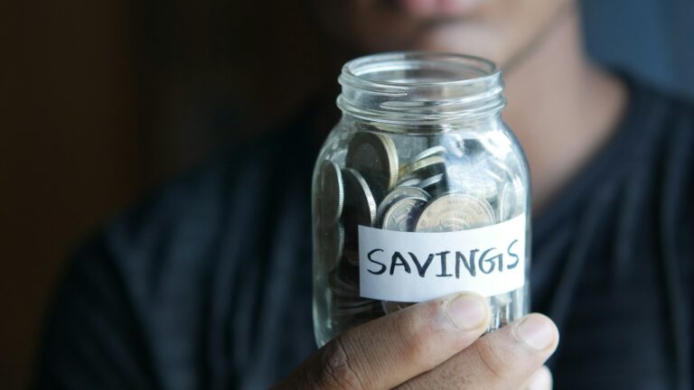 a man holding a jar with a savings label on it